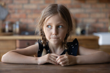 Head shot portrait of sly little girl with guilty scared face and shut mouth. Funny kid looking away, keeping silence about tricks, avoiding punishment. Childhood, young age problems concept - obrazy, fototapety, plakaty