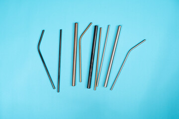 A group of different colour and types of metal straws in a blue backdrop.  Save the sea animals and reduce plastic usage! 