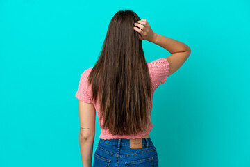 Young Brazilian woman isolated on blue background in back position and thinking