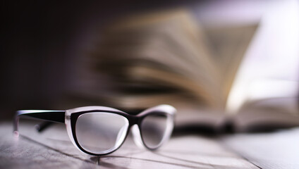 Composition with glasses and open book on the table