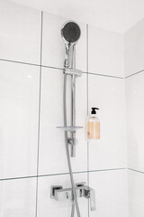 Shower column with mixer. Interior of a modern shower room. The shower gel is attached on a white...