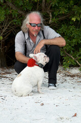 Long haired man wearing sunglasses with frenchie, french bulldog.