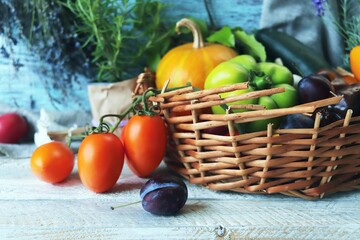 Fresh ripe vegetables and fruits in a basket, on a wooden table, harvest concept, organic natural products, healthy food, home cooking
