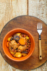 Jewish dish chelnt with meat on the table in a plate on a round wooden stand.