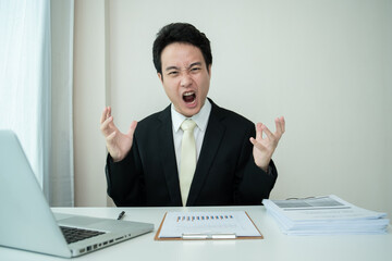 Unhappy Asian young businessman feels very upset and despair.