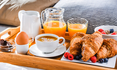 A tray with breakfast on a bed in a hotel room