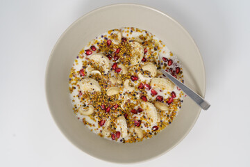 Müsli mit Blütenpollen, Kokosraspeln, Granatapfel und Bananen
