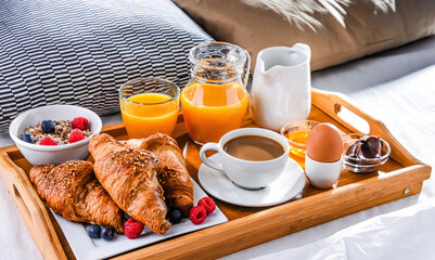 A tray with breakfast on a bed in a hotel room