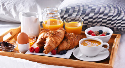 A tray with breakfast on a bed in a hotel room
