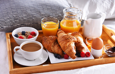 A tray with breakfast on a bed in a hotel room