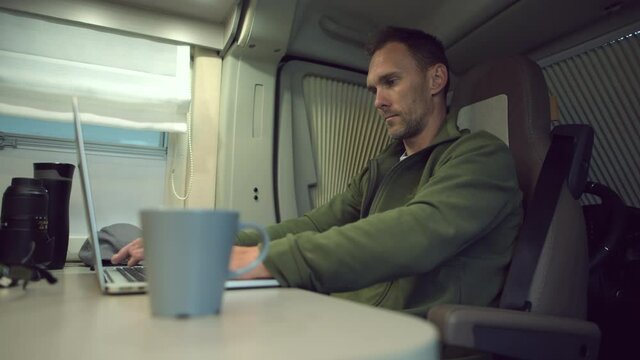 Men Working Remotely From His Camper Van RV Motorhome on His Computer While on a Road Trip