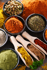 Variety of spices on wooden kitchen table.