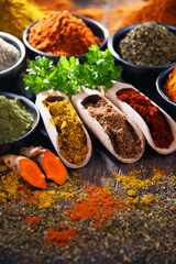 Variety of spices on wooden kitchen table.