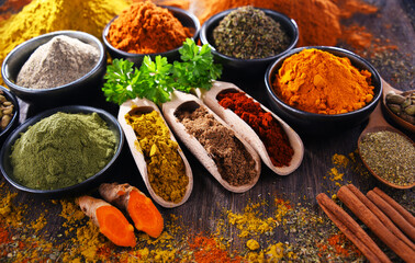 Variety of spices on wooden kitchen table.