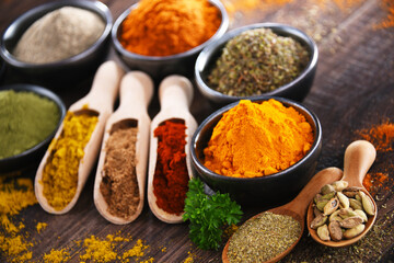 Variety of spices on wooden kitchen table.