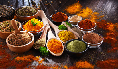 Variety of spices on wooden kitchen table.