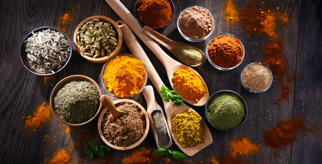 Variety of spices on wooden kitchen table.