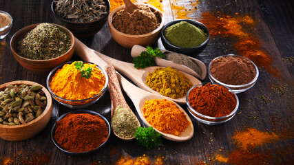 Variety of spices on wooden kitchen table.