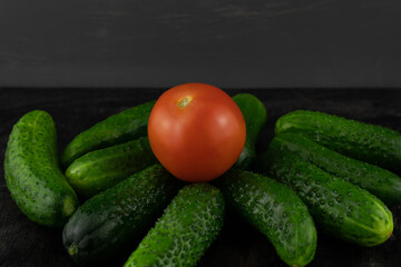 One tomato and a bunch of cucumbers