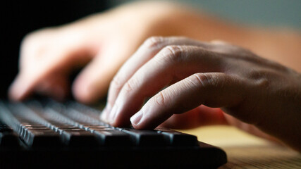 The man is typing on the keyboard.