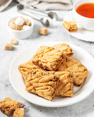  Shortbread cookies with cherry jam on a white plate on a light gray kitchen table. Delicious homemade sweet pastries