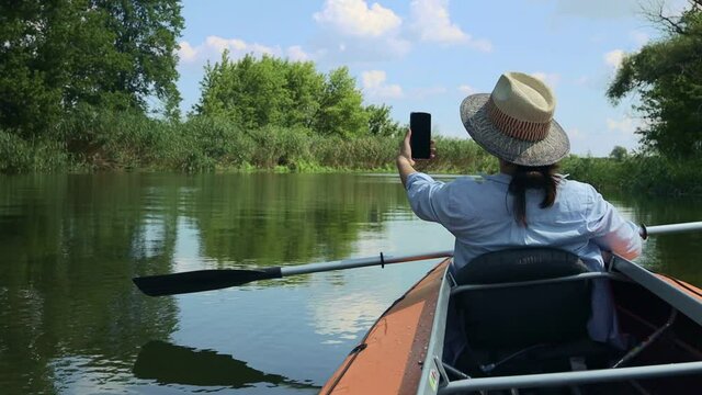 young woman making selfie on kayak boat on the river