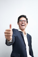 young latin man in suit laughing out loud with thumb up, ok sign of approval, on a white background