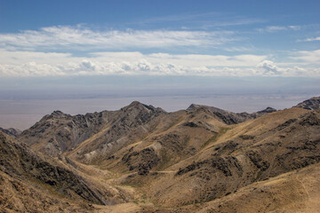 Beautiful Summer scenery: yellow and brown mountains under the blue cloudy sky. Central Asian mountain background. 