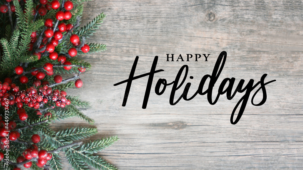 Wall mural happy holidays script text with holiday evergreen branches and red berries on side over rustic wood 