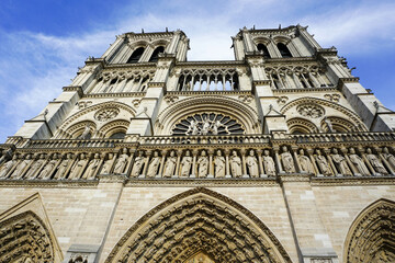Low angle shot of Cathedrale Notre-Dame de Paris under a blue cloudy sky in France