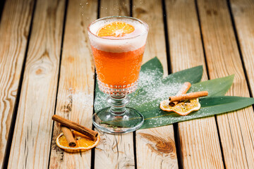 orange rum cocktail and spritz aperol with airy foam and orange chips on a wooden background with lines and cinnamon sticks. bar menu concept