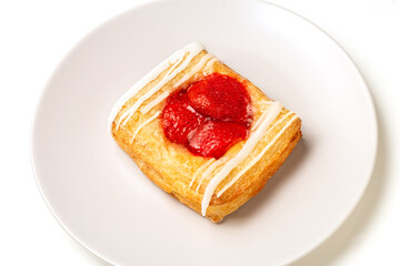 Puff pastry patties with strawberries on a plate. Puff pastry filled. White background.