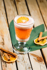 orange rum cocktail and spritz aperol with airy foam and orange chips on a wooden background with lines and cinnamon sticks. bar menu concept