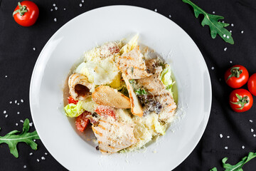 Caesar salad with chicken and parmesan cheese on a white plate