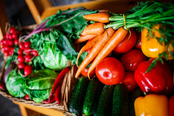 a box of fresh vegetables at the market. box with carrots, red peppers, cabbage, cucumbers and radishes