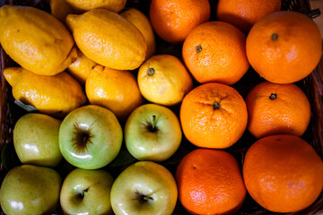 a box of lemons and oranges and apples in the market