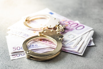 Euro banknotes and handcuffs.