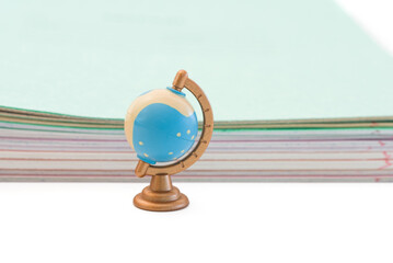 small globe on the background of school notebooks