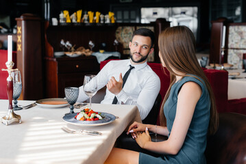 A young beautiful couple is having lunch in a fine restaurant. Customer service in the catering.