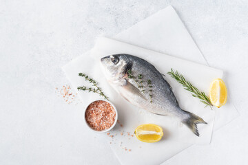 Seafood. Fresh raw dorado fish with spices. Ingredients for cooking or grill on cutting board. Top view, copy space