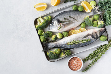 Seafood. Fresh raw dorado fish with spices. Ingredients for cooking or grill on cutting board. Top view, copy space