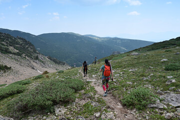 Fototapeta na wymiar Hikers descend Saint Mary's Glacier Trail in Arapaho National Forest, Colorado on sunny summer afternoon.