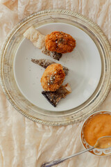 Snack of fried fish fritters and crispy fish skin on metal serving platter
