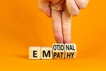 Emotional empathy symbol. Doctor turns wooden cubes and changes the word 'Emotional' to 'Empathy'. Beautiful orange table, orange background, copy space. Psychology, emotional empathy concept. - obrazy, fototapety, plakaty