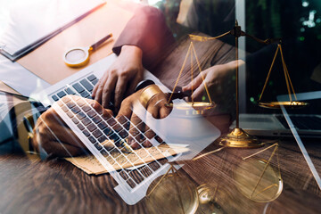 Justice and law concept.Male judge in a courtroom with the gavel, working with, computer and docking keyboard, eyeglasses, on table in morning light