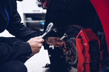 Man car mechanic repairing car brakes in car service