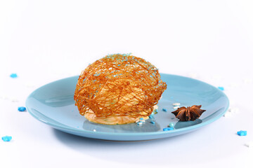 Ice cream in sugar caramel on a blue plate.