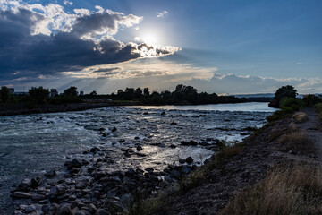 Beautiful sunset over Sava river rapids in Zagreb city, with storm clouds approaching fast,...