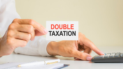 double taxation, message on business card shown by a woman