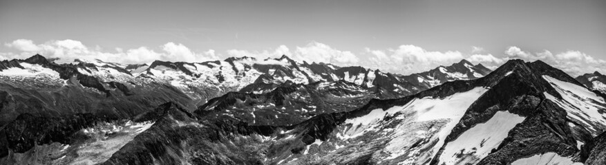 Alpnine rocky peaks panorama on sunny summer day. Austrian Alps, Austria. Black and white image.